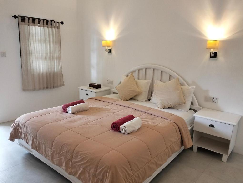 a bedroom with a large bed with two pillows on it at White Coconut Resort in Gili Trawangan