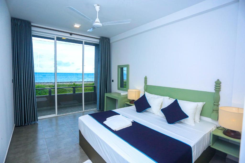 een slaapkamer met een bed en uitzicht op de oceaan bij Villa beachcomber in Ambalangoda