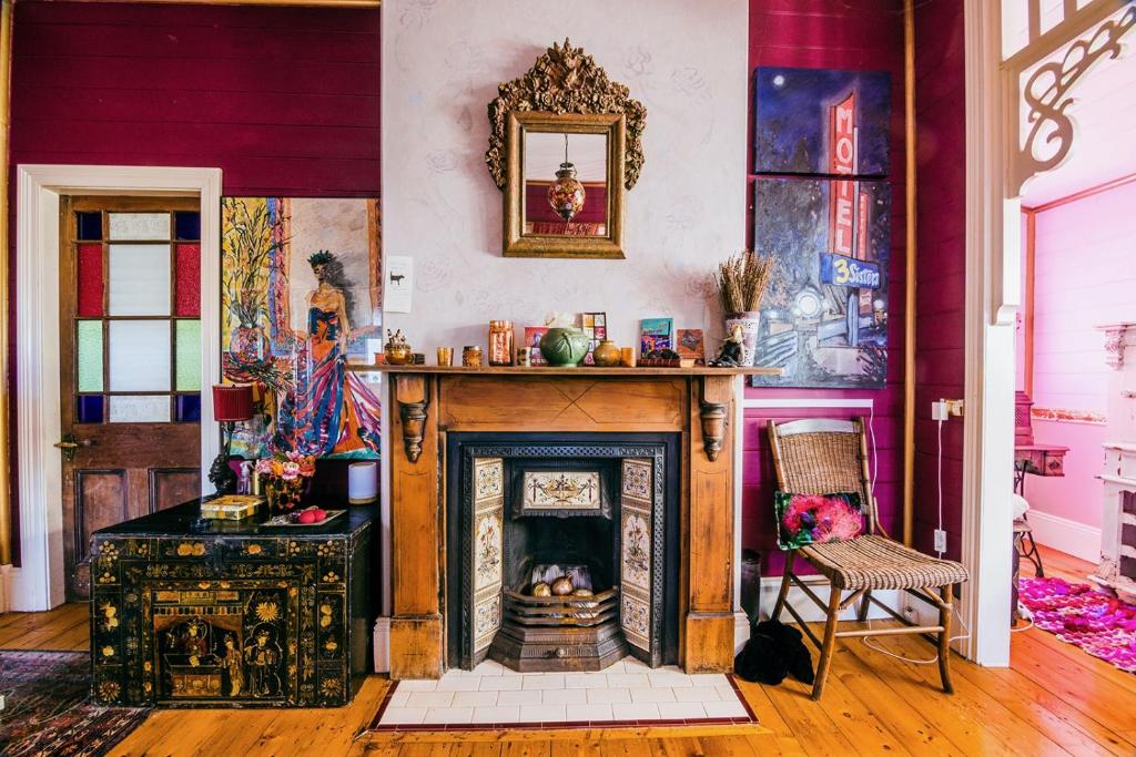 a living room with a fireplace and a wall with paintings at Chinoiserie in Katoomba