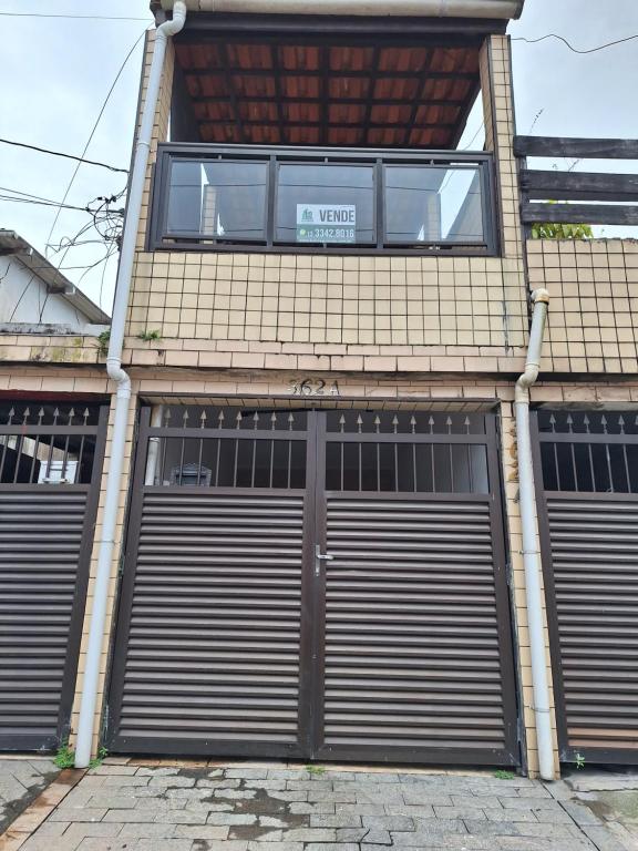un edificio con dos puertas de garaje con un cartel. en Recanto do Sossego, en Guarujá