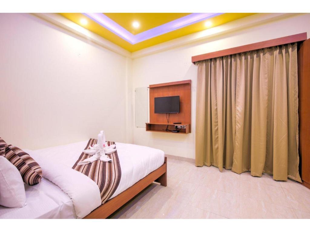 ein Schlafzimmer mit einem Bett und einem TV. in der Unterkunft Kusum House in Greater Noida