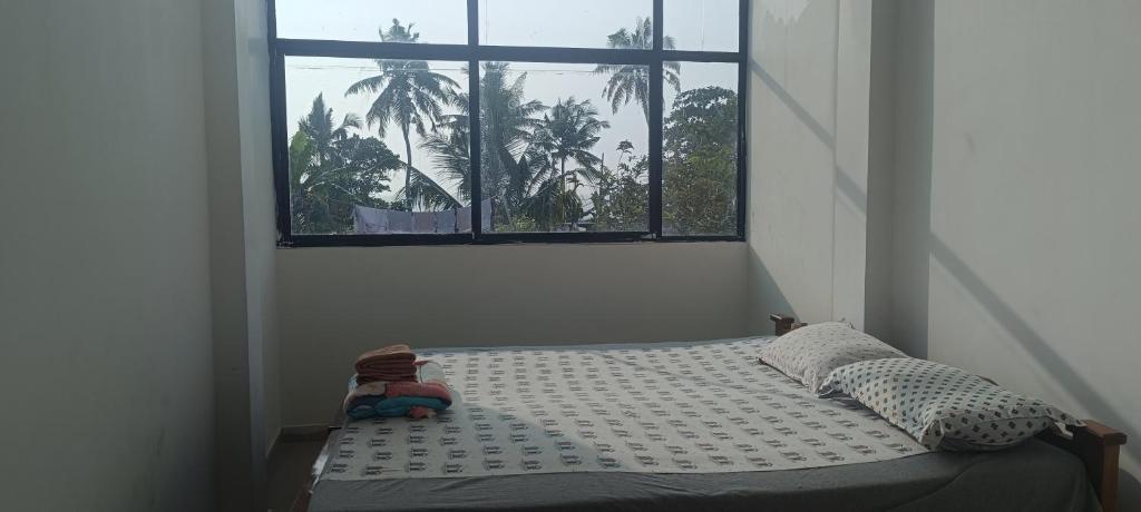 a bed in a room with a window at Beach vibe hostel in Alleppey