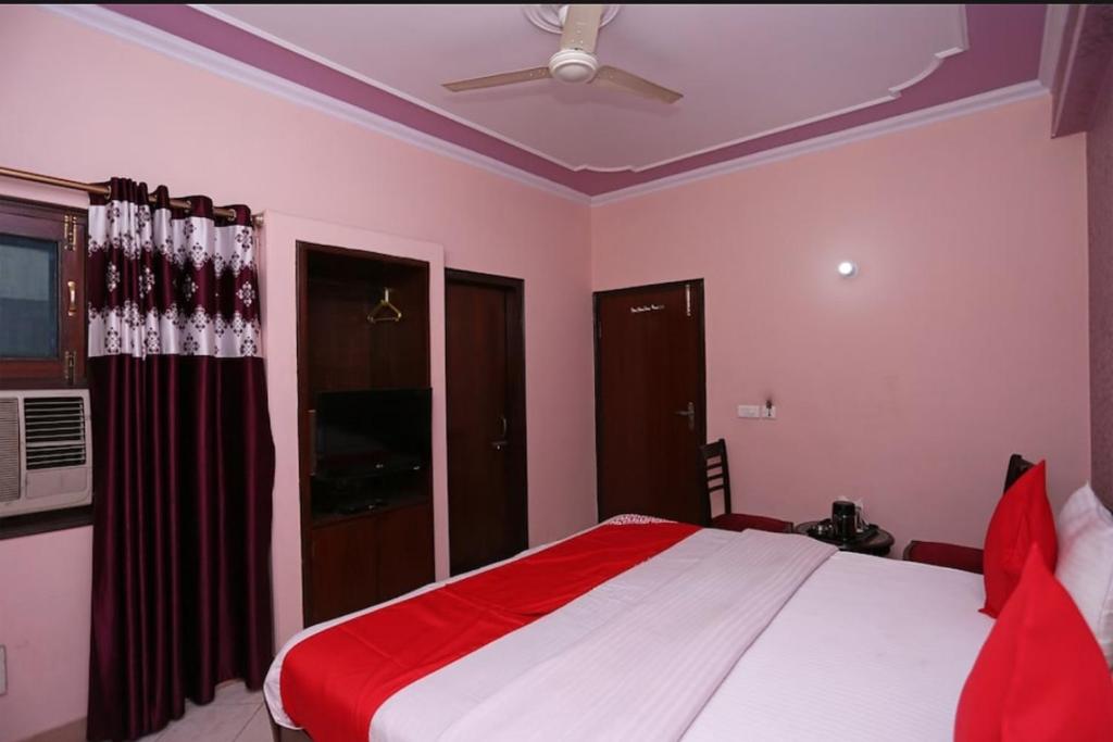 sypialnia z łóżkiem i wentylatorem sufitowym w obiekcie Hotel The New Avenue w mieście Aligarh