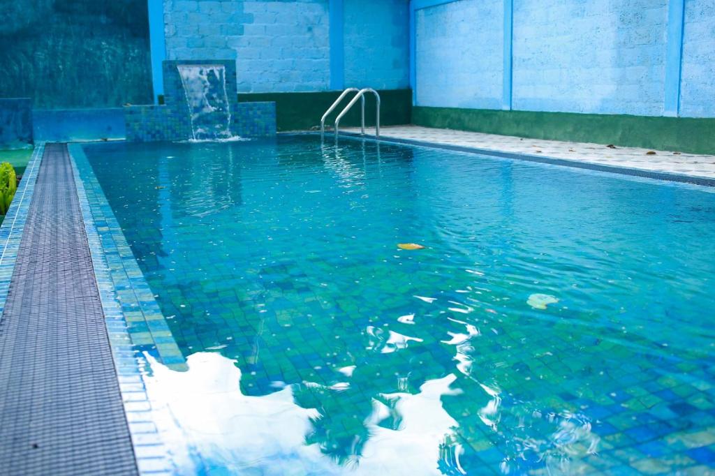 a swimming pool with blue water in a building at Villa Eco Green Airport in Katunayake