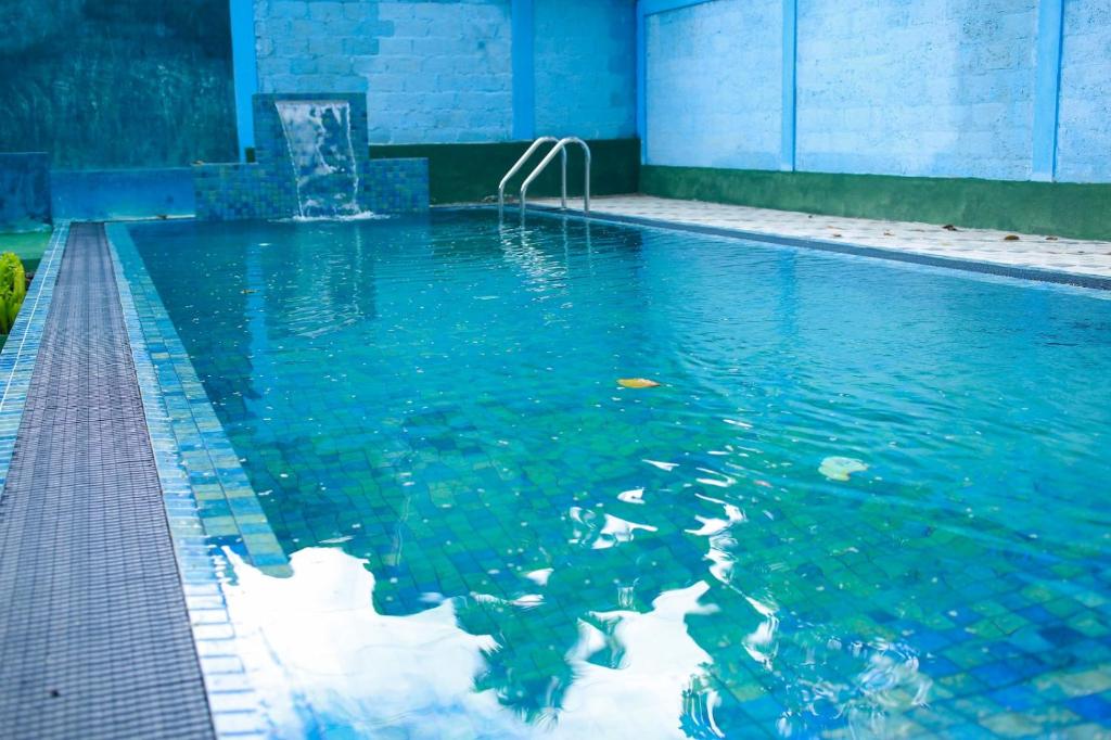 a swimming pool with blue water in a building at Villa Eco Green Airport in Katunayaka