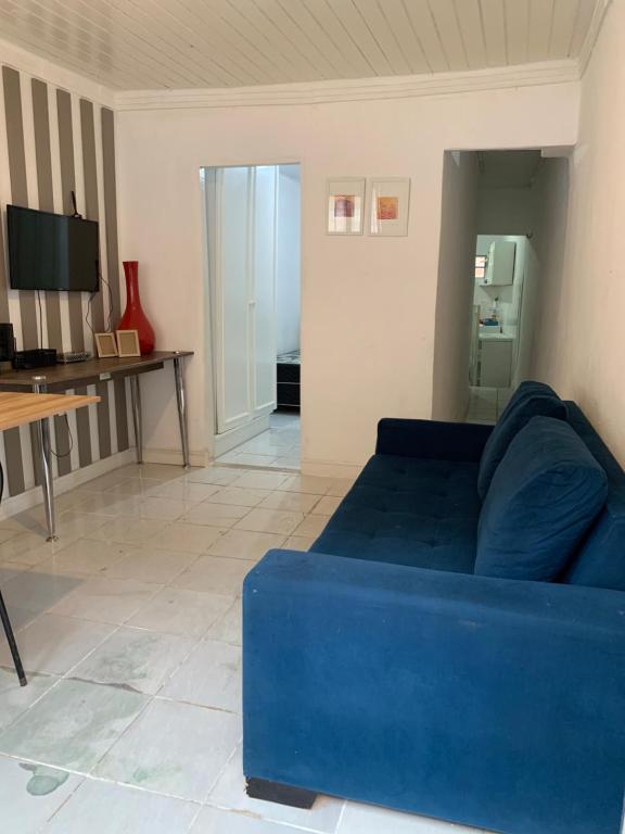 ein Wohnzimmer mit einem blauen Sofa und einem Tisch in der Unterkunft Casa simples in Belém