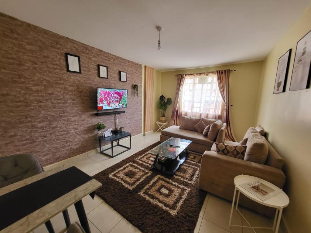 a living room with a couch and a tv at Eclectic 2 bedrm homely & comfy in Machakos