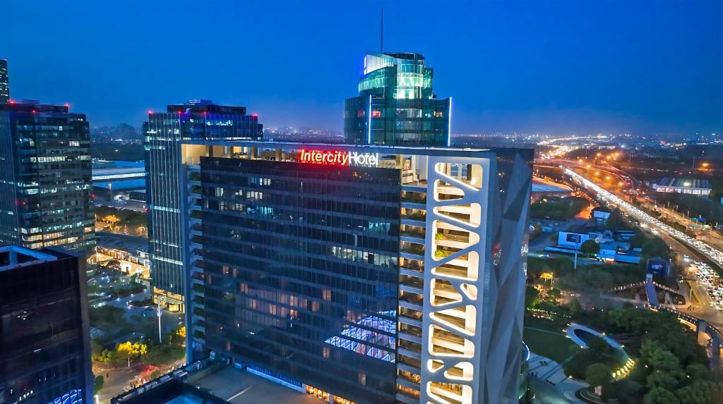 a tall building with a sign on it at night at IntercityHotel Shanghai New International Expo Center in Shanghai