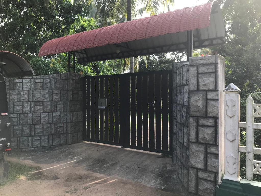 a gate with a stone wall and a fence at VinSri Transit Home , Narammala, Kadahapola in Narammala