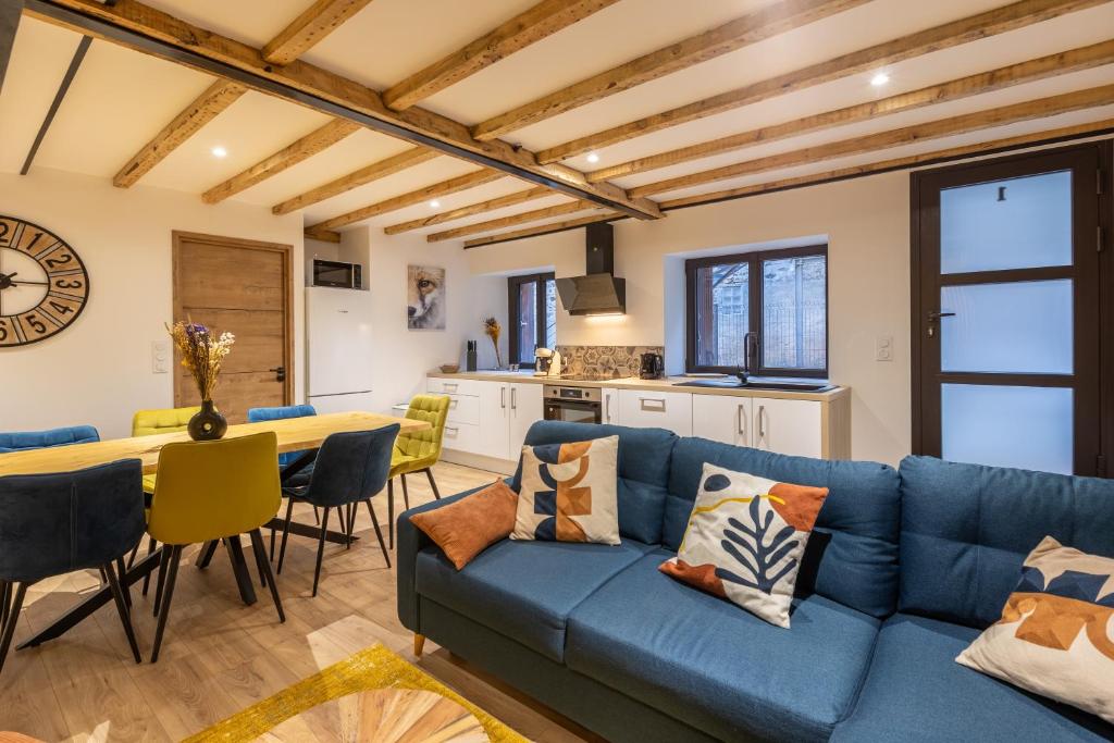 sala de estar con sofá azul y mesa en Le Cocon Enneigé - Duplex 3 chambres, en Formiguères