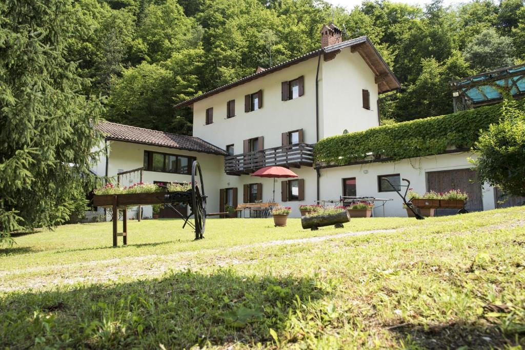 un grand bâtiment blanc avec une cour et une maison dans l'établissement Agriturismo Maso Rocca, à Ala