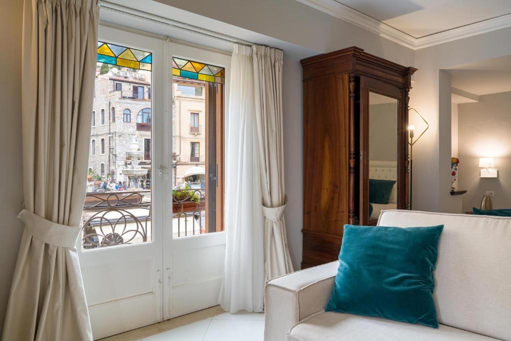 un soggiorno con divano e finestra di Al Duomo Rooms & Flats a Taormina