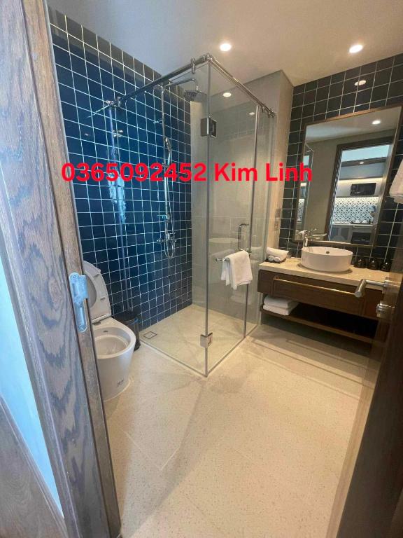 a bathroom with a shower and a toilet and a sink at APEC Mandala Mũi Né - Kim Linh in Mui Ne