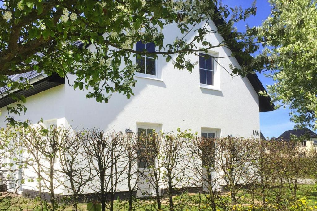 una casa blanca con árboles delante de ella en Holiday Resort Van der Valk, Linstow, en Linstow