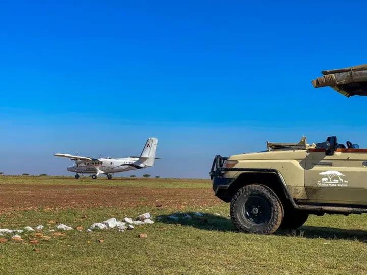 a plane is on a field with a military vehicle at MASAI MARA COTTAGES in Narok