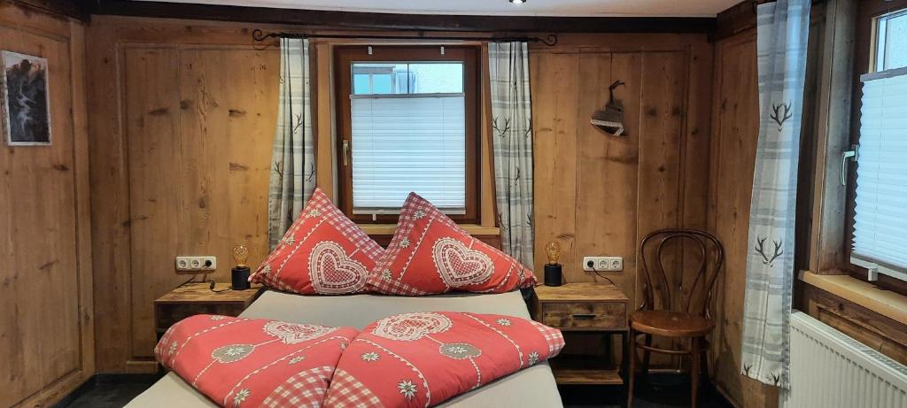 ein Schlafzimmer mit einem Bett mit roten Kissen darauf in der Unterkunft Dora's Lechtraum in Bach
