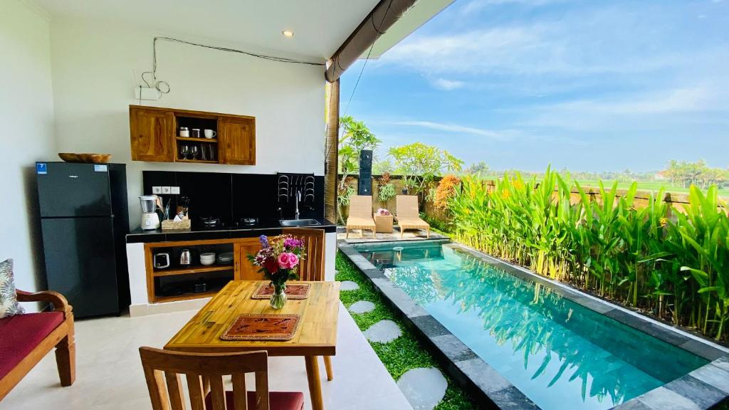 cocina con mesa y piscina en Villa magica, en Ubud