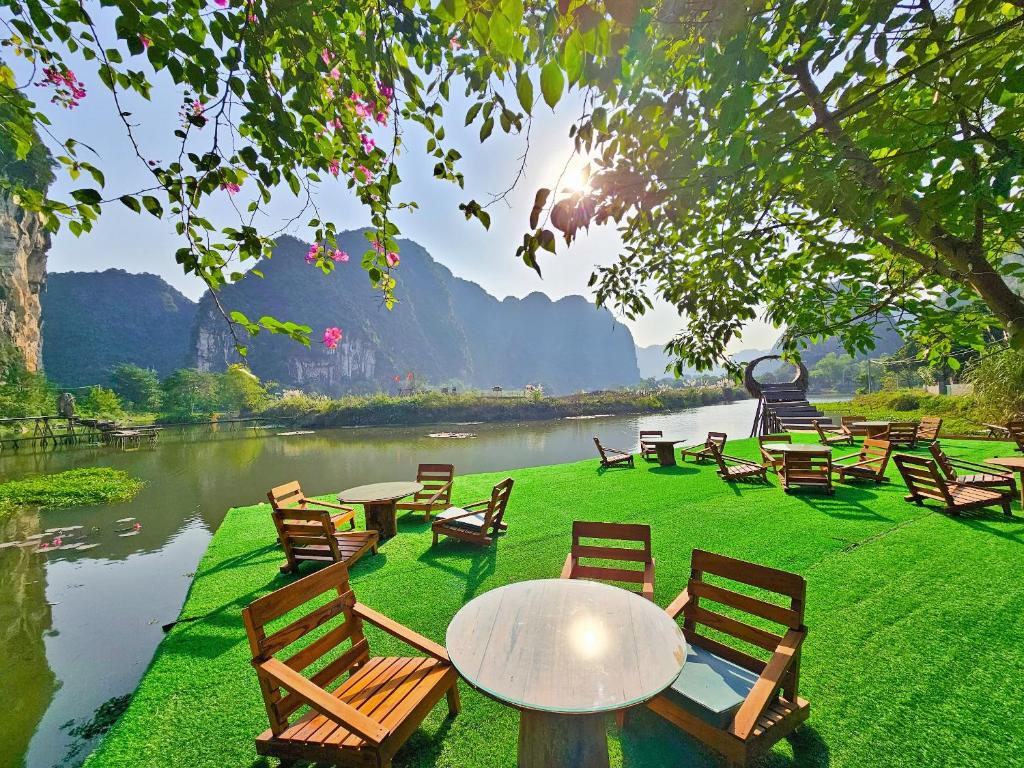 een groep stoelen en een tafel naast een rivier bij Quoc Khanh Bamboo Homestay in Ninh Binh