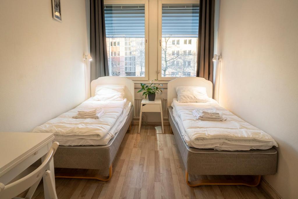 two beds in a room with a window at Göteborg Hostel in Gothenburg