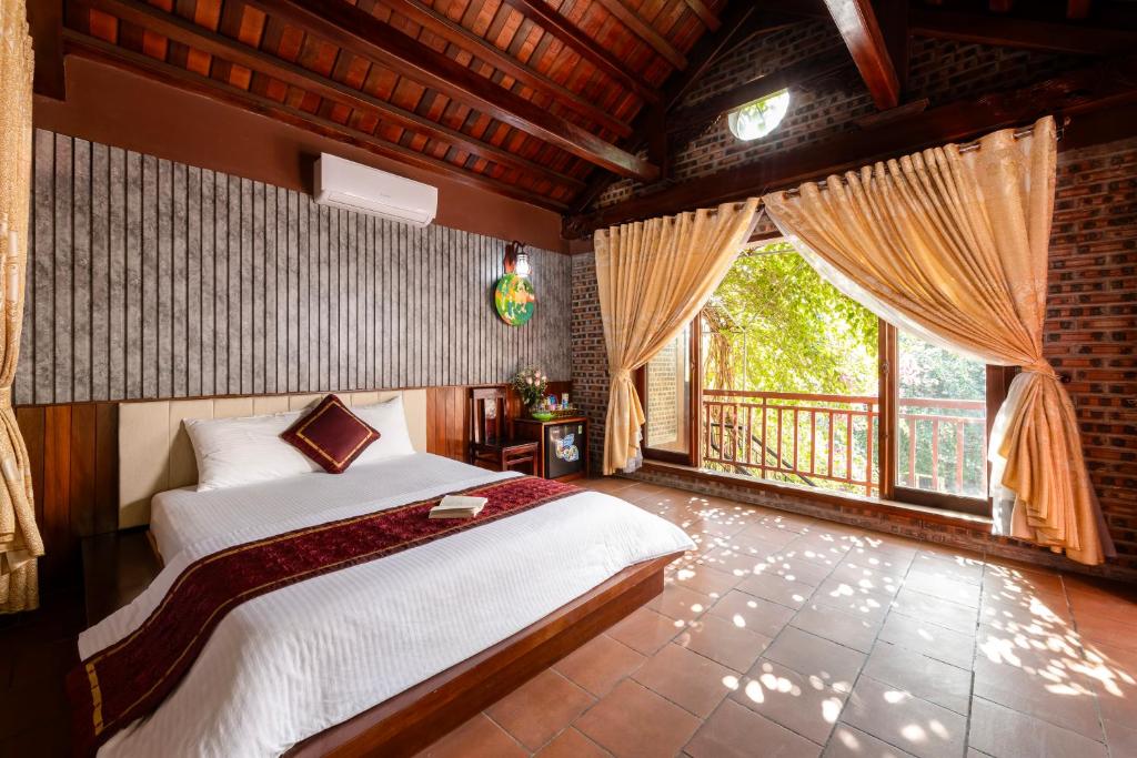 una camera con un letto e una grande finestra di Tam Coc Ngoc Linh Bungalow Ninh Bình a Ninh Binh
