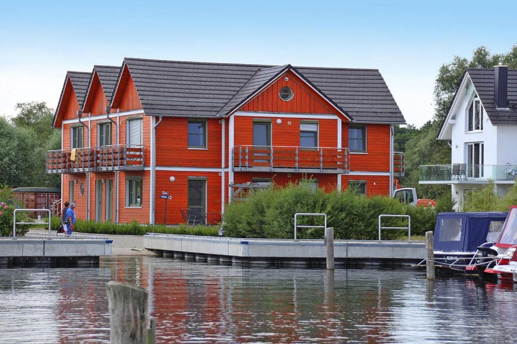 a large red house on the water with a marina at Wohnung in Plau am See in Plau am See
