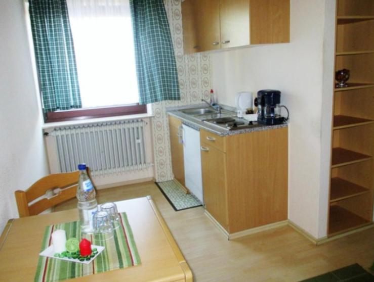 a small kitchen with a table and a sink and a counter at Lenche Gasthaus Neumayer 