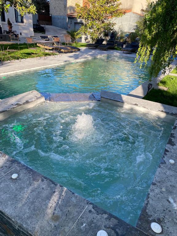 a swimming pool with blue water in a yard at Demeure Saint Louis Historic manor, City 700m, parking,A C,Clim,WIFI, heated pool, city view in Carcassonne