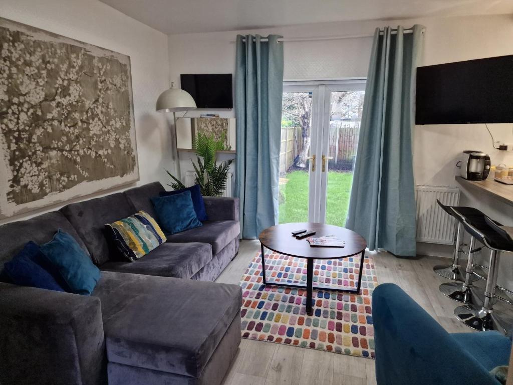 a living room with a couch and a table at Modern 4-bed house with garden & parking in Walsgrave on Sowe