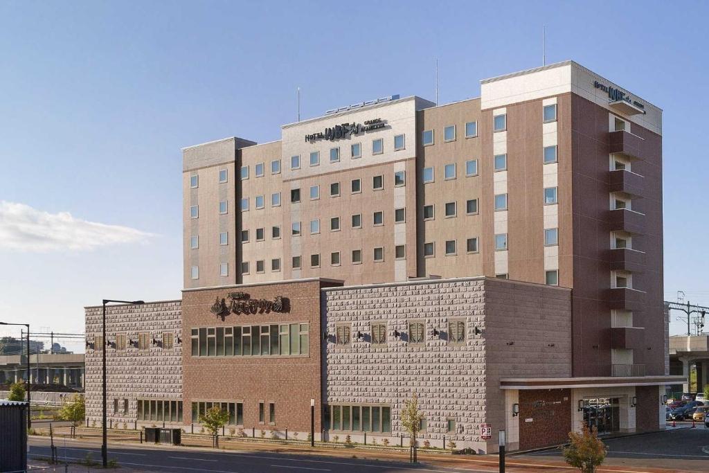 a large building on the corner of a street at Hotel WBF Grande Asahikawa in Asahikawa