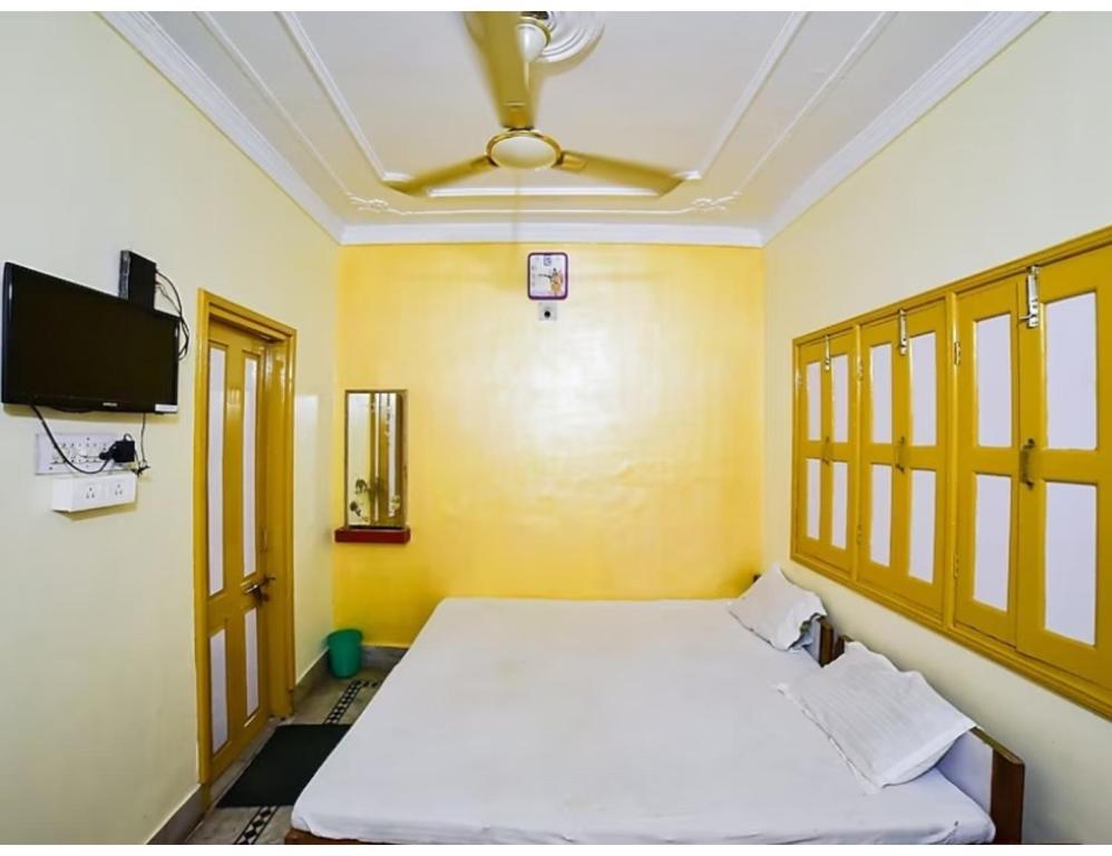 a bedroom with a bed and a ceiling fan at Shivam Guest House, Gaya in Gaya