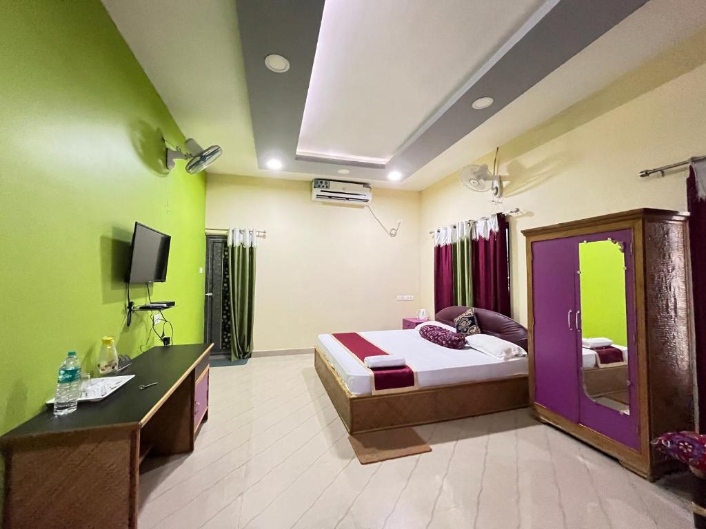 1 dormitorio con 1 cama, escritorio y TV en Green Reed Homestay, en Kāziranga