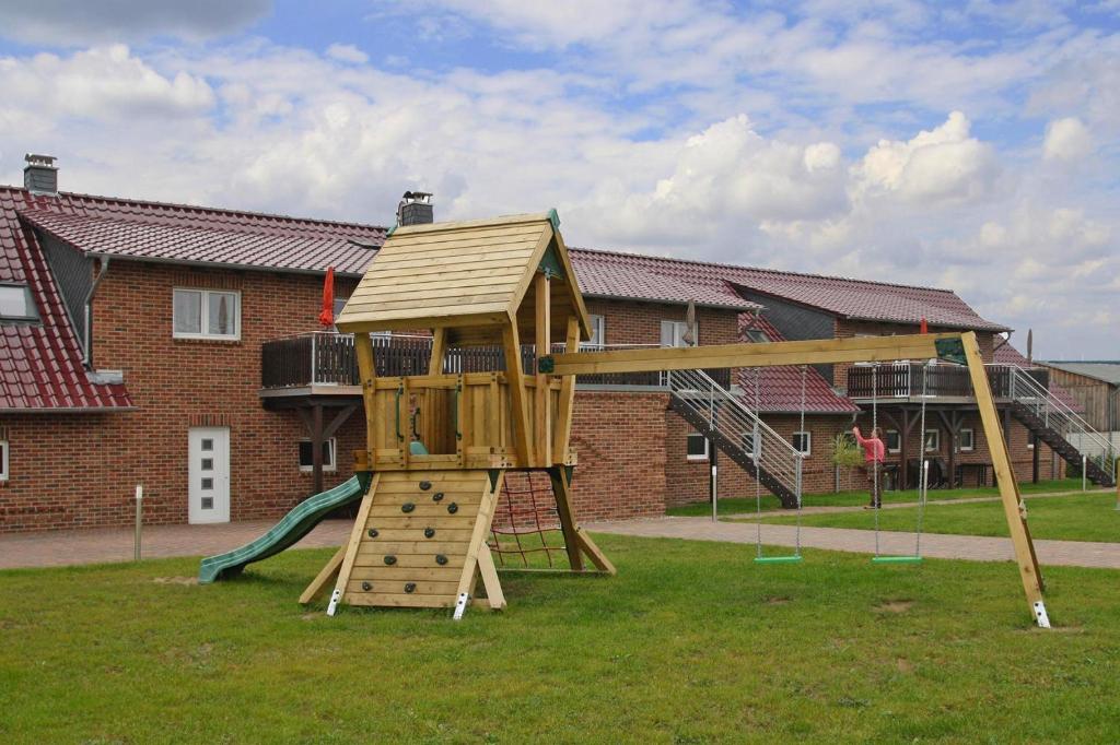 a wooden playground with a slide in a yard at Ferienhof Mirow, Mirow in Mirow