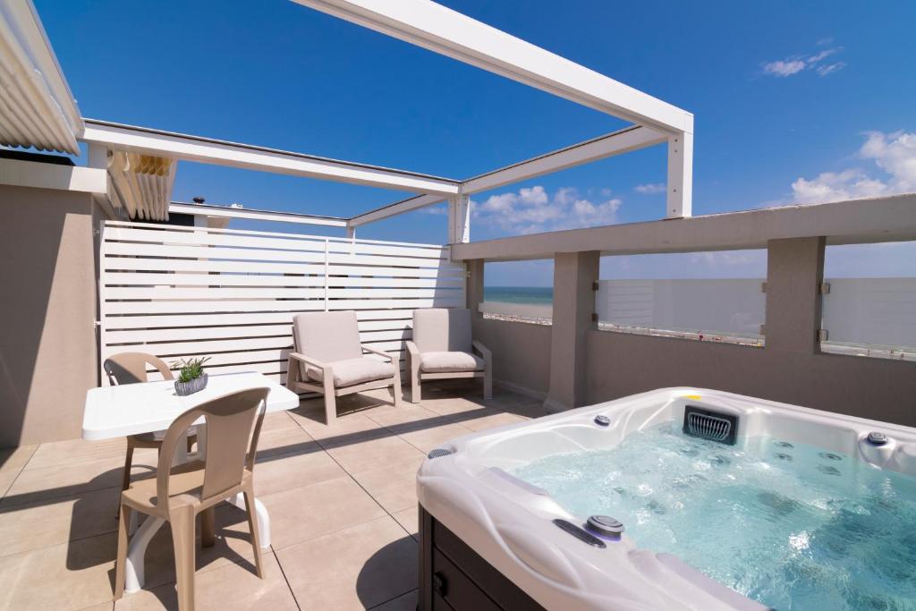 a hot tub on a balcony with a table and chairs at Residence Flow-R in Riccione
