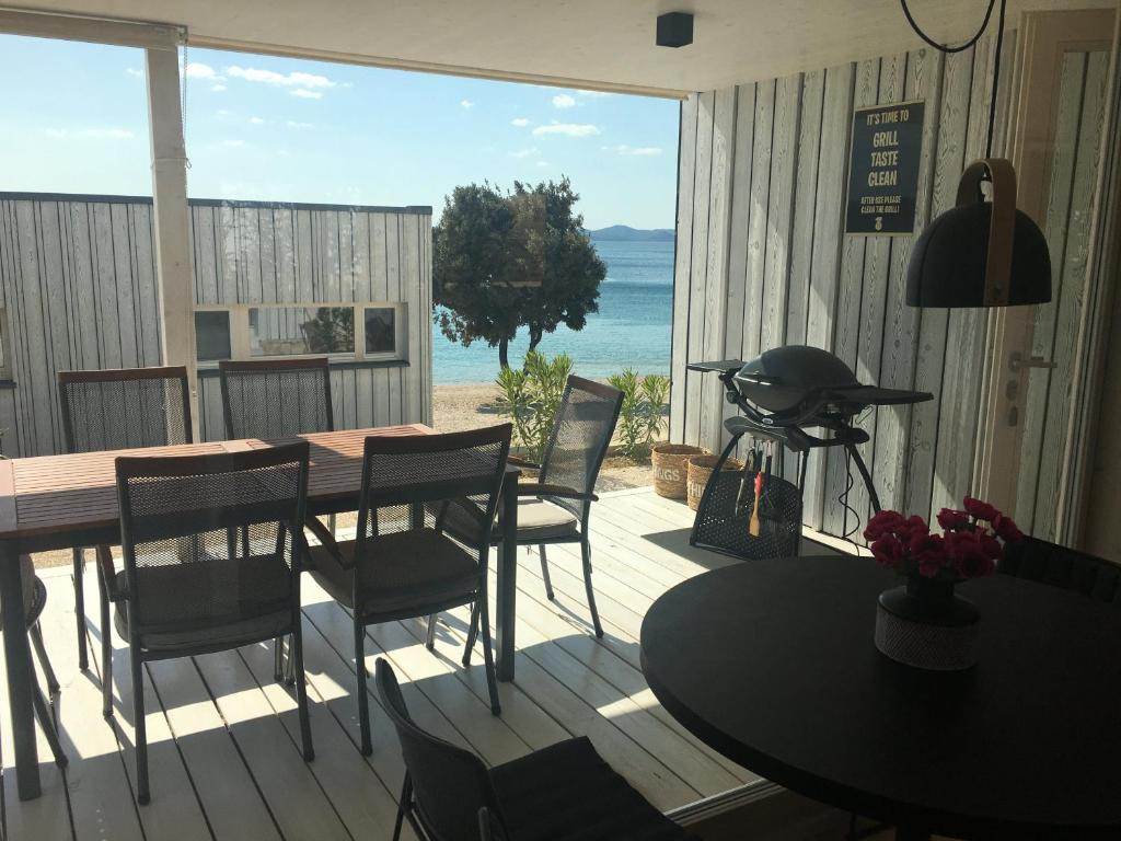 a porch with a table and chairs and a view of the ocean at Buqez Eco Resort - Villa 33 in Drage