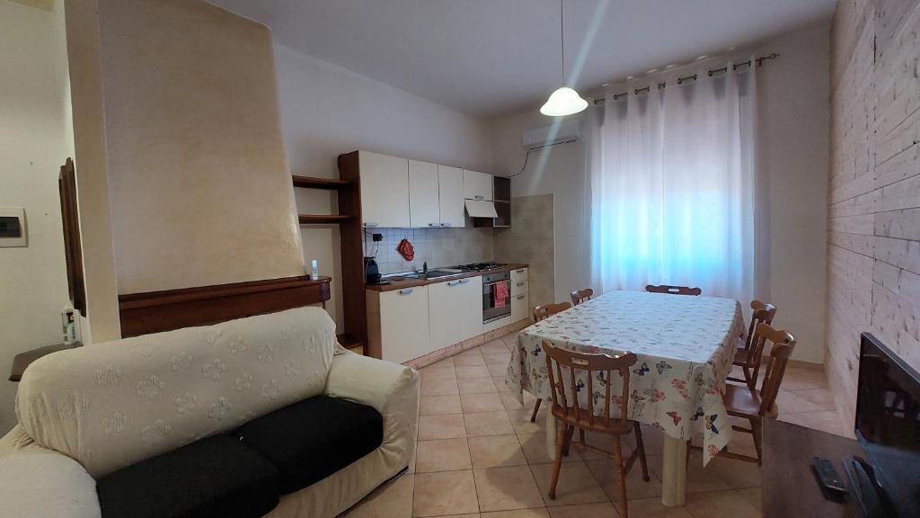 sala de estar con mesa, sofá y cocina en Casa Gigli, en Villagrande Strisaili