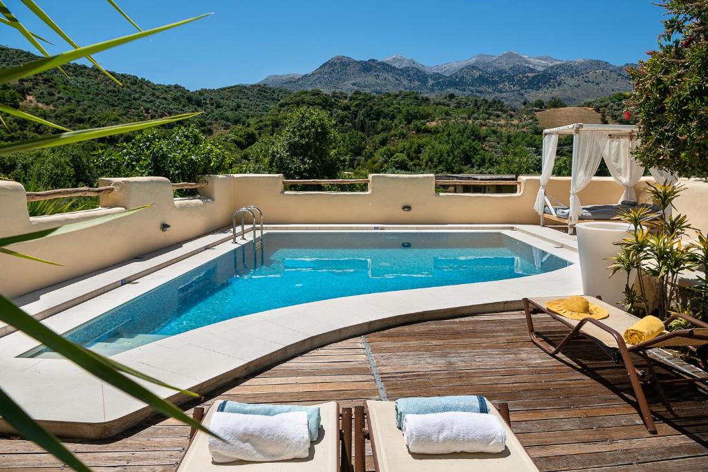 a swimming pool with a view of the mountains at Verekinthos Villas in Yerolákkos