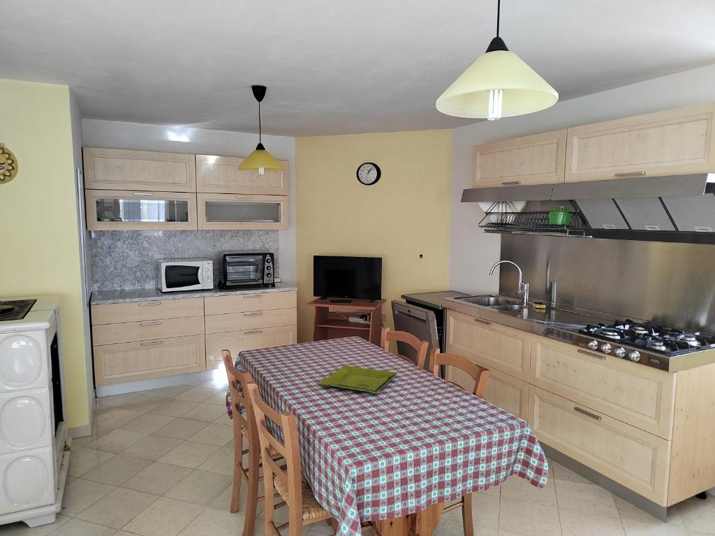 a kitchen with a table and a kitchen with a table and chairs at Chalet Migazzi in Cogolo