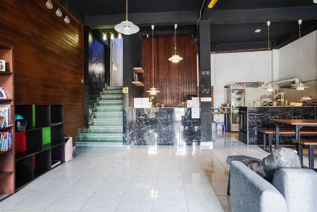 a lobby with a staircase and a table and chairs at Bali Backpacker Inn & Hostel in Ubud