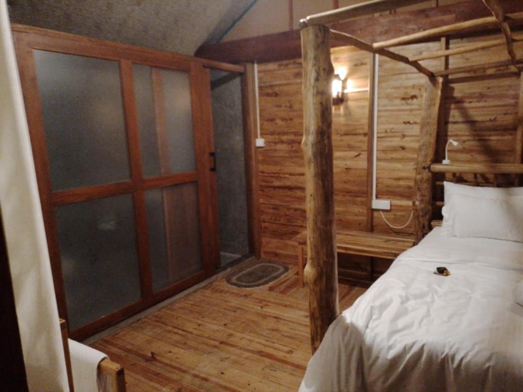 a bedroom with a bed in a wooden cabin at LAMIACEAE WOOD CABIN in Ella