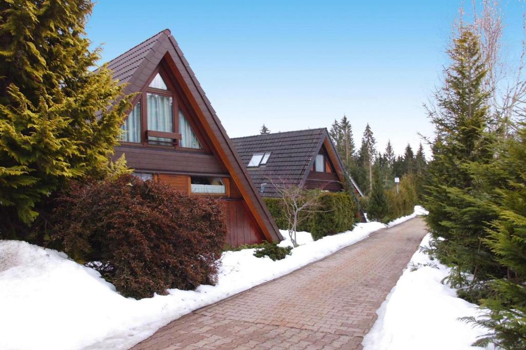 ein Haus mit einer Backsteinstraße im Schnee in der Unterkunft Tennenbronn Holiday Park Tennenbronn in Tennenbronn