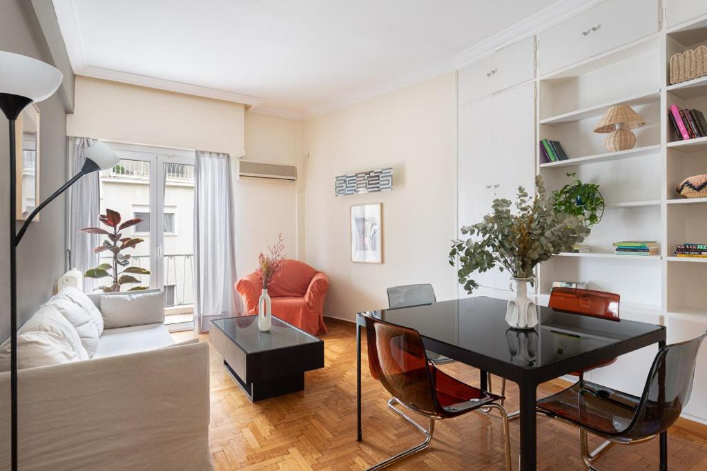 ein Wohnzimmer mit einem Tisch und einem Sofa in der Unterkunft Athenian Apartment in Kolonaki in Athen