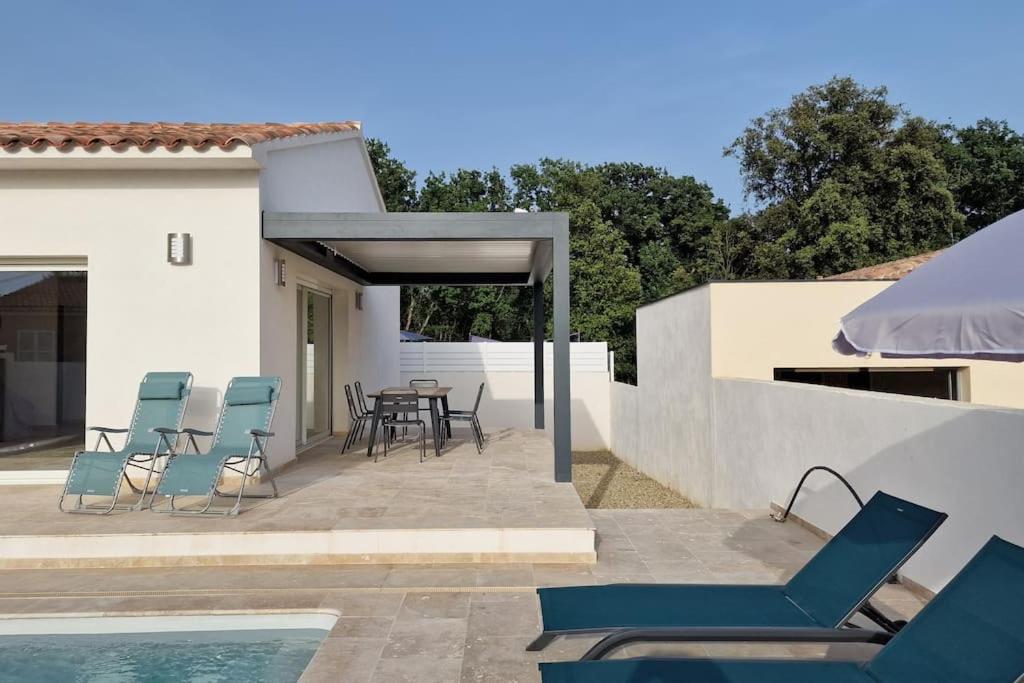 eine Terrasse mit Stühlen, einem Tisch und einem Pool in der Unterkunft "Villa Querciu" Villa neuve & piscine privée in Prunelli-di-Fiumorbo