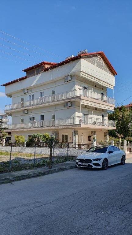 オリンピアキ・アクティにあるFrideriki Apartmentsの大きな建物の前に駐車した白車