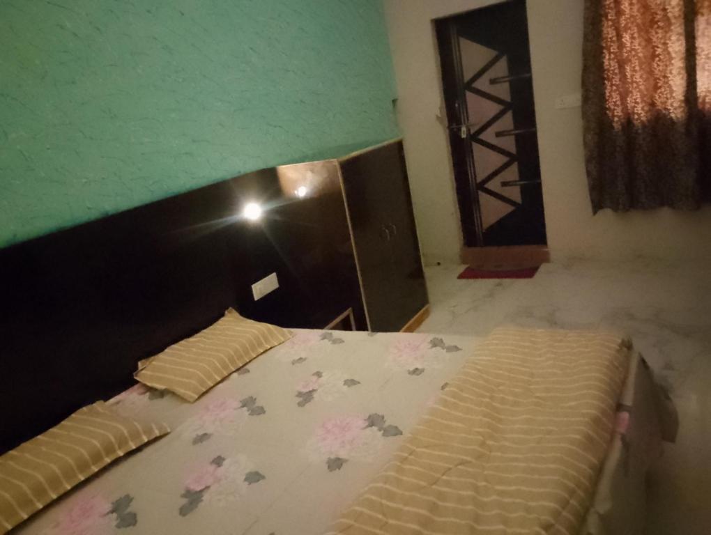 um quarto com uma cama e uma parede verde em S.R home stay em Agra