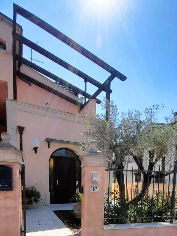 a building with an archway and a building with a fence at La Chiocciola Apartments in Santarcangelo di Romagna