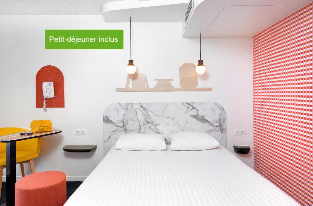 um quarto com uma cama branca e uma mesa em Hôtel ibis Styles Vichy Centre em Vichy