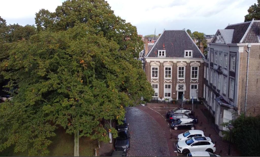 een groep auto's geparkeerd op een parkeerplaats naast een gebouw bij B&B Cleyn Cruysenborgh 1531 in Dordrecht