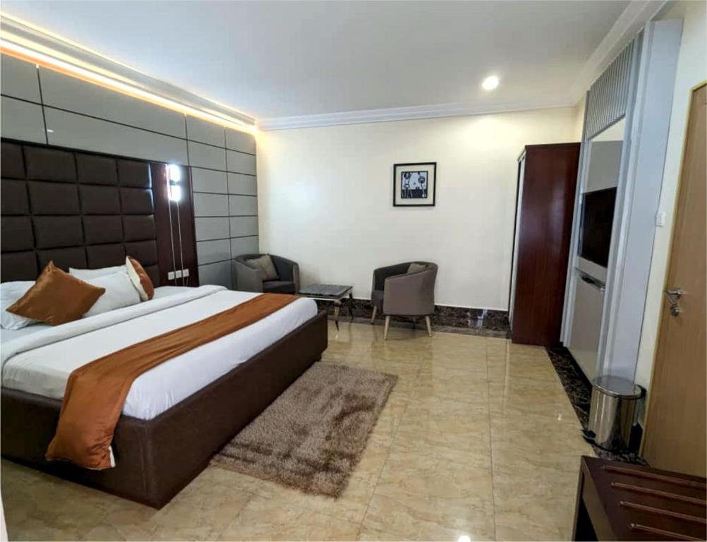 a hotel room with a large bed and a desk at Newton Park Hotels Annex in Abuja