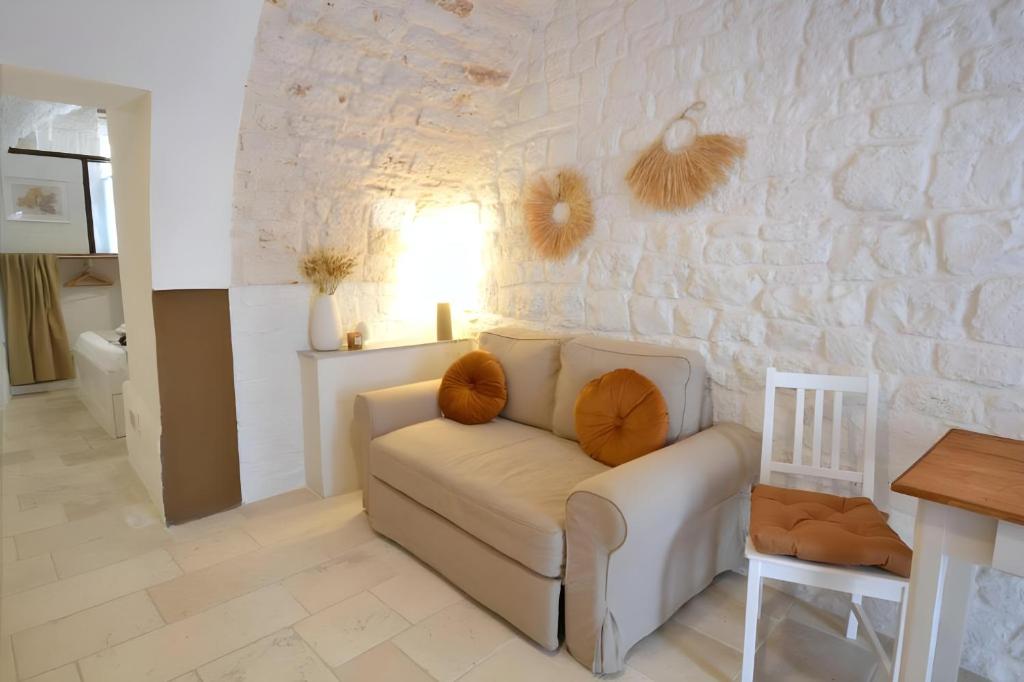 a living room with a couch and a stone wall at Casa Matteotti by Wonderful Italy in Conversano