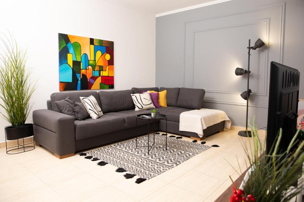 - un salon avec un canapé et un tableau dans l'établissement Maris Apartment, à Tirana